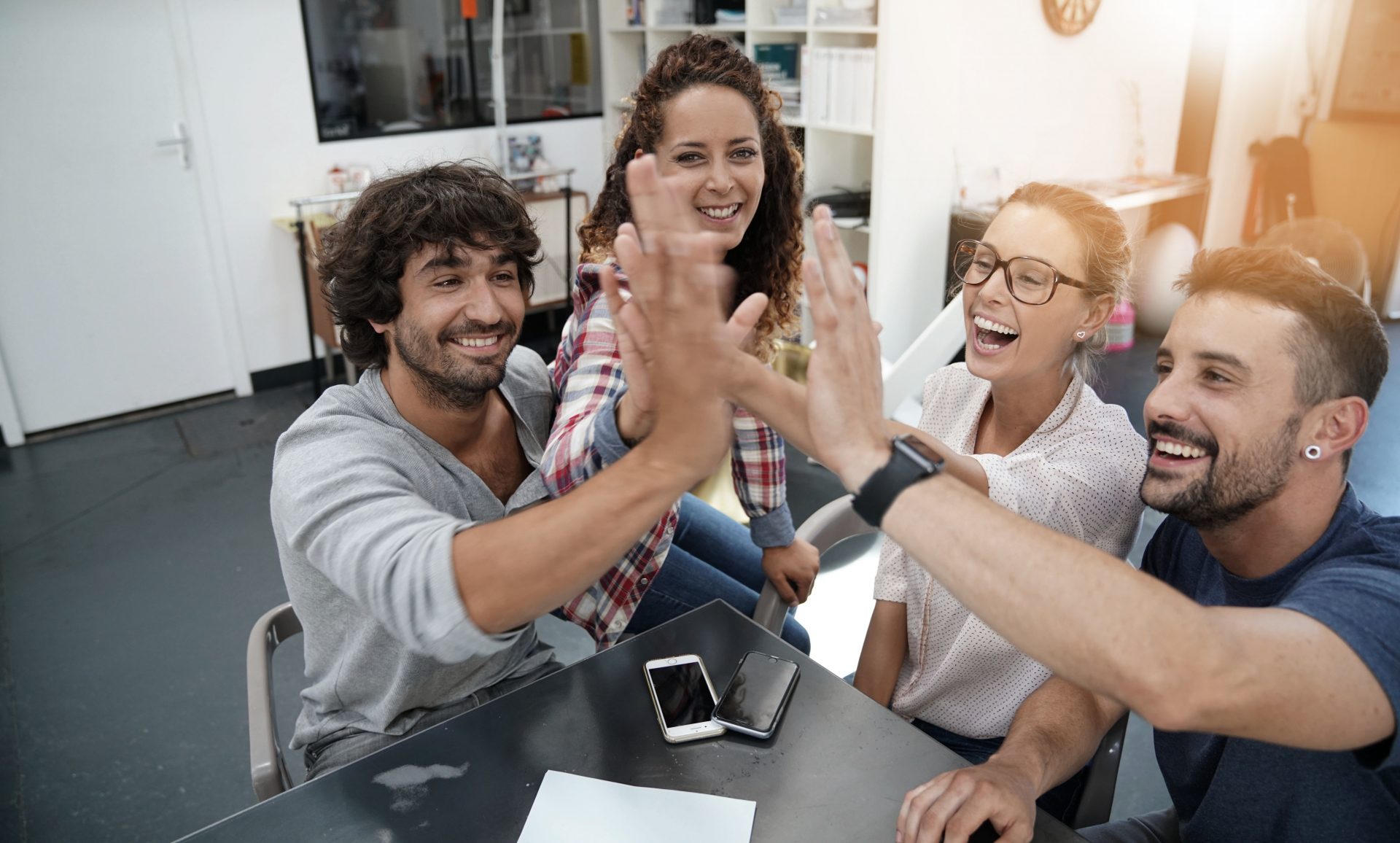 Group of working people giving one another high five